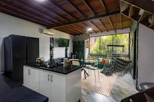 サンタ・フェ・デ・アンティオキアにあるApto Centro histórico Santa fe de Antioquiaのキッチン(白いキャビネット、黒いカウンタートップ付)