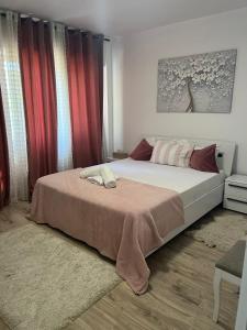 1 dormitorio con 1 cama grande y cortinas rojas en Soft Apartments, en Galaţi 2 fotos más