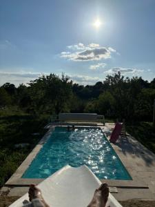 Ventenac-CabardèsにあるPlein cœur de la nature ~ Jacuzzi Privé 24h/24hの空に太陽が降り注ぐスイミングプール