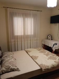 a bedroom with a bed with a window and a table at Casa Boris in Bîrsana +11 photos
