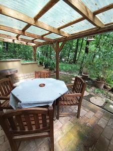 a table and chairs under a wooden pergola at Őzike-Lak a Börzsönyben in Kismaros