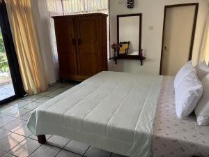 Un dormitorio con una gran cama blanca y una ventana. en Aqua Leisure Resort Bentota, en Bentota