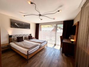 a bedroom with a bed and a large window at Alpenlodge in Zermatt