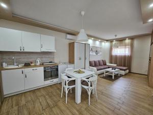 a kitchen and living room with a table and chairs at Apartmani i sobe Gromilovic in Sombor