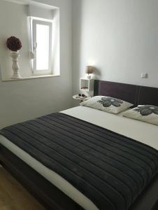 a bedroom with a large bed with a blue blanket at Cozy apartment Di in Dubrovnik