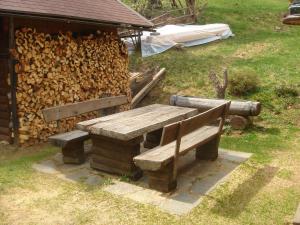 a wooden bench next to a pile of fire wood at Chalet in Kolbnitz near Ski Slopes in Penk