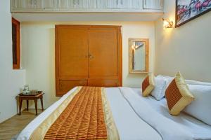 a bedroom with a large bed and a wooden cabinet at Hill View 2BHK Homestay with Garden - 2 Bedrooms with Living room Kitchen and 2 Washrooms in Nainital