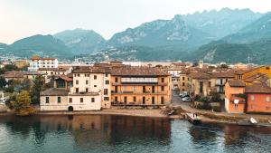 a group of buildings on the shore of a body of water at RioLago - Appartamento sul fiume a Lecco in Lecco