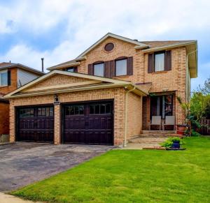 a brick house with two garage doors at 4 Bedroom Spacious Retreat near Key Attractions in Mississauga