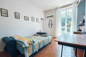 a bedroom with a bed and a table and a window at RioLago - Appartamento sul fiume a Lecco in Lecco