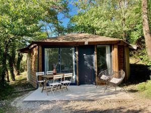 Ventenac-CabardèsにあるPlein cœur de la nature ~ Jacuzzi Privé 24h/24hの小さなキャビン(テーブルと椅子付)