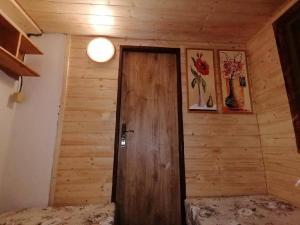 a wooden door in a room with two beds at Chata Roubenka in Jedovnice