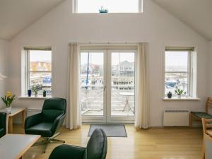a living room with green chairs and a large window at 6 person holiday home in Rudkøbing in Rudkøbing