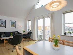 a living room with a table and chairs and windows at 6 person holiday home in Rudkøbing in Rudkøbing