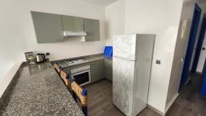 a kitchen with a refrigerator and a stove at Aloha Imsouane vue sur mer in Imsouane +32 photos
