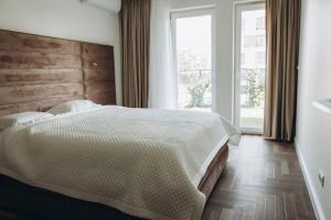 une chambre avec un lit et une grande fenêtre dans l'établissement Elegancki Apartament Park Bażantów, à Katowice