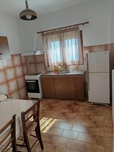 a kitchen with a refrigerator and a table with chairs at ANATOLI ROOMS SERIFOs in Serifos Chora