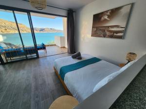 a bedroom with a bed with a view of the ocean at Aloha Imsouane vue sur mer in Imsouane