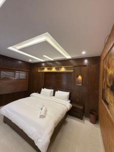 1 dormitorio grande con 1 cama grande con sábanas blancas en Go Glam Hotel Murree, en Murree