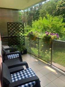 a porch with chairs and a balcony with flowers at Apartament dwupokojowy in Gollnow