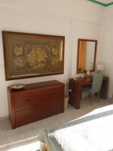 Un dormitorio con una cama, un escritorio y un espejo. en Green Living, en Mytilini