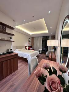 a hotel room with a bed and a table with roses at Homestay LUXHOME RESIDENCE - HOMESTAY OCEAN PARK in HÆ°ng YÃªn