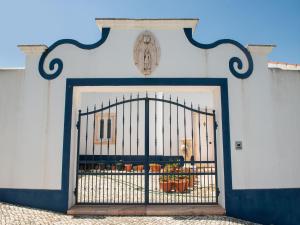a gate in a wall with a cagedigunigunigunigunigunigunigun at Your Montemor-o-Novo Mansion Escape in Montemor-o-Novo