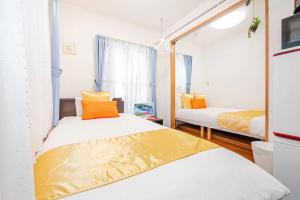 a bedroom with two beds and a mirror at Akihabara Skytree Premium Apartment 201 in Tokyo