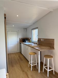 a small kitchen with a counter and two stools at Studio à la campagne in Charols