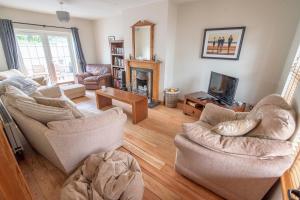 a living room with two chairs and a fireplace at Corner Cottage in Castlerock