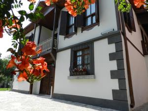 biały budynek z oknami i pomarańczowymi kwiatami w obiekcie Aslibey Konaği - Adults Only w mieście Sapanca