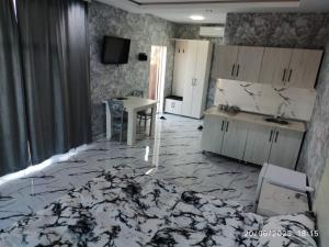 a room with a bed and a table and a kitchen at Kirayə Evler in Astara