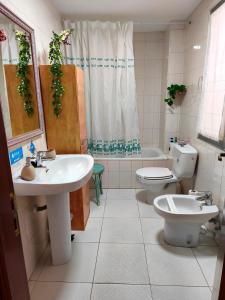 a bathroom with two sinks and a toilet and a shower at Casa Pita in San Justo de la Vega