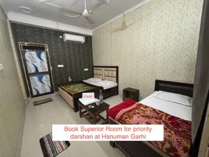 a hotel room with two beds and a sign that reads book superior room for priority at Omji - Shri Ram Janki Ashram, 20 min walk to Ram Janmabhumi Temple in Ayodhya