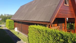 a house with a brown roof and some bushes at Wantaris - domki letniskowe z ogródkiem Mielno-Mielenko in Mielno