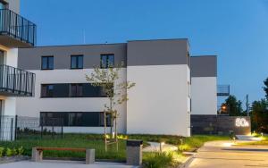 a white building with a bench in front of it at WRZOSOVA APARTMENT Tarnów in Tarnów +8 photos