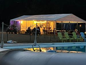 a group of people in a tent next to a pool at Le calme in Braize