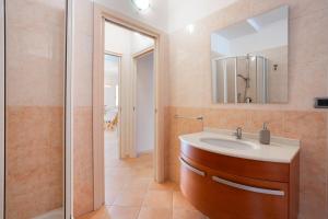 Un baño con lavabo, espejo y ducha. en Villa Lolly, en Quartu SantʼElena 34 fotos más
