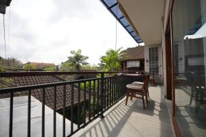 a balcony of a house with a table and chairs at Nuna House Ubud in Ubud +8 photos