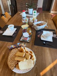a table with a plate of bread and other foods at Chambre d'hôte à Sieck in Santec +8 photos