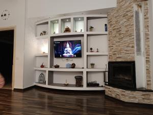 a living room with a tv and a fireplace at Noah's Seaside in Golem