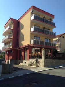 a tall apartment building with balconies on a street at Sveti Vlas niki house in Sveti Vlas