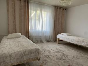 a bedroom with two beds and a window at Azem Guest House in Kasymbek