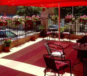 a patio with tables and chairs under an umbrella at Sveti Vlas niki house in Sveti Vlas
