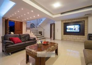 a living room with a couch and a tv at Villa Kristia in Paphos City