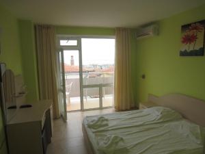 a bedroom with a bed and a desk and a window at Sveti Vlas niki house in Sveti Vlas