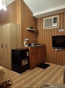 a kitchen with wooden walls and a sink and a refrigerator at كوخ ريفي تنومة in Tanomah