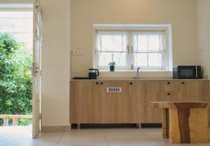a kitchen with a sink and a window at Fursatghar Aangan Studio Apartment in Bīr