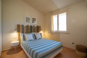 Un dormitorio con una cama con rayas azules y blancas. en Villa Lolly, en Quartu SantʼElena