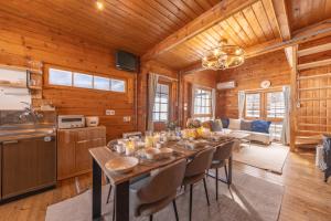 a dining room with a table and a kitchen at green bell in Myoko